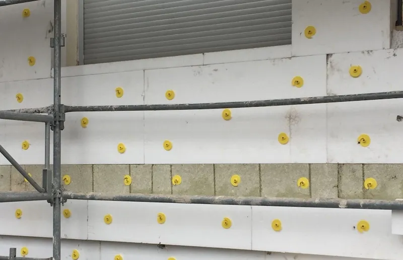 Panneaux isolants chevillés sur une façade en cours d'isolation par l'extérieur